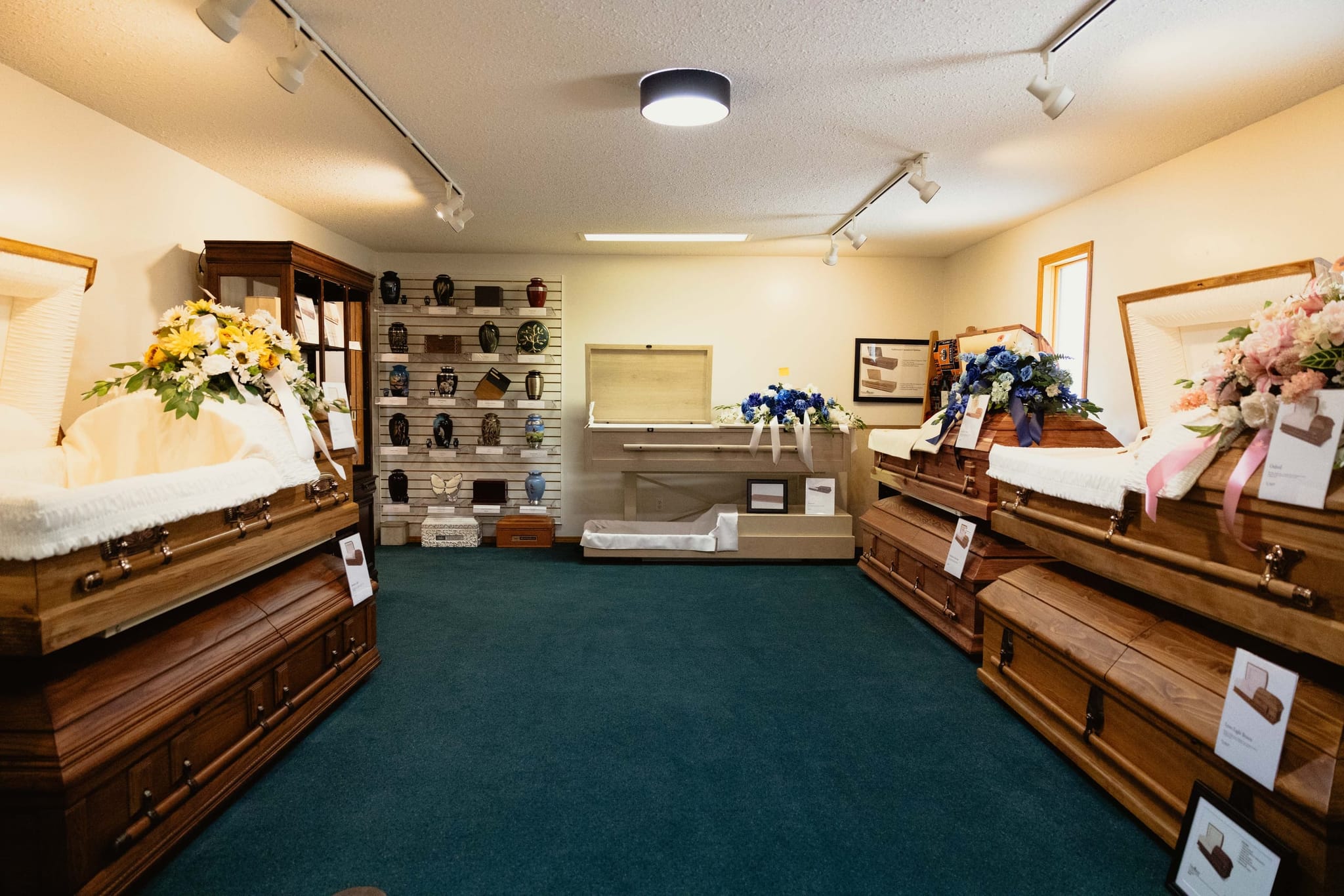The selection room at Athabasca Community Chapel with caskets on display beside a wall of memorial urns.