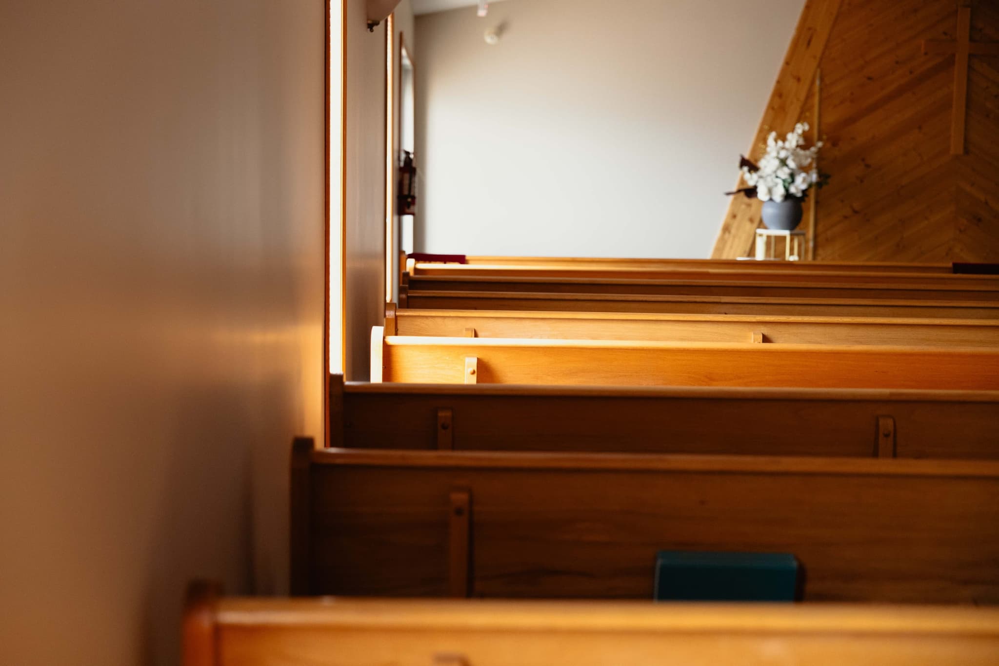 Chapel pews at Athabasca Community Chapel with white flowers along the aisle
