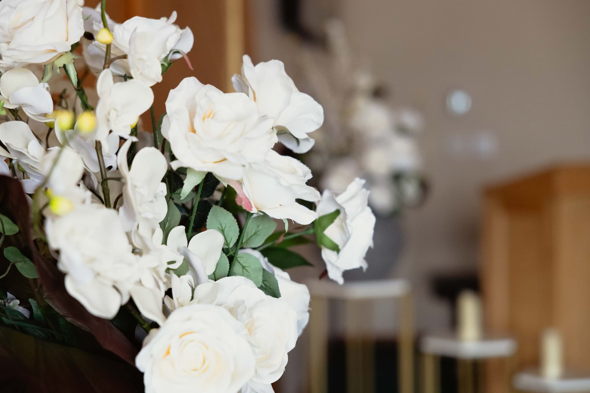 White silk roses and orchids with candle stands at Athabasca Community Chapel, a gentle setting for bereavement support in Athabasca
