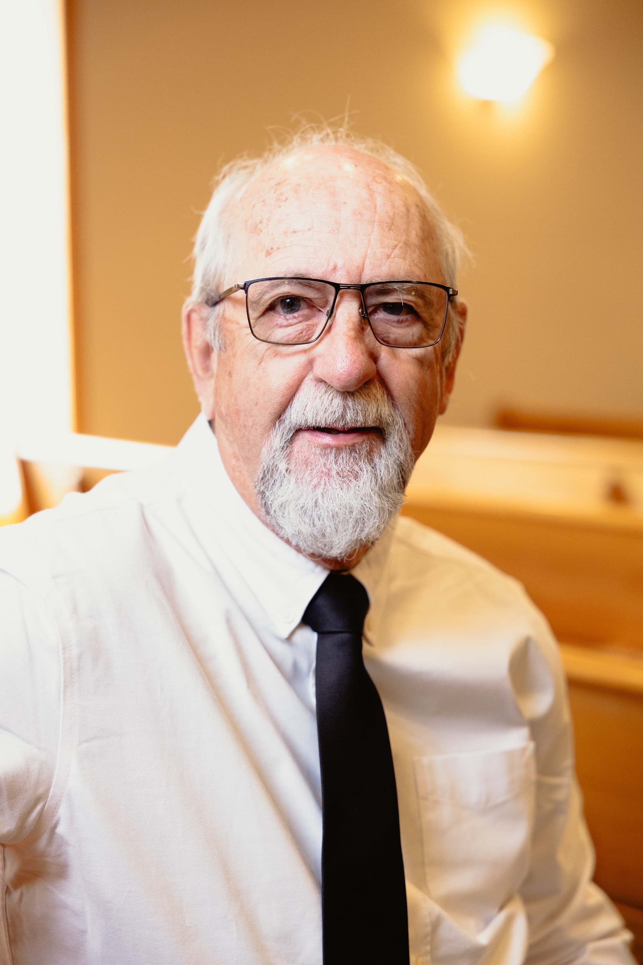 A funeral director at Athabasca Community Chapel, seated in the chapel, part of the dedicated licensed local staff serving families